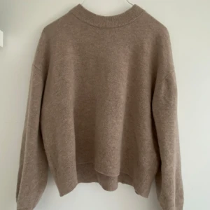 Beige stickad tröja från Samsøe Samsøe - Säljer en mysig beige stickad ull tröja från Samsøe Samsøe. Tröjan har en rund halsringning och långa ärmar. Den har en enkel och stilren design som passar till det mesta. Ej använd mkt ❤️