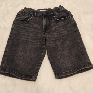Svarta jeansshorts - Snygga svarta jeansshorts med klassisk femficksdesign. De har en bekväm passform och är perfekta för en avslappnad stil. Shortsen har en dragkedja och knapp framtill.