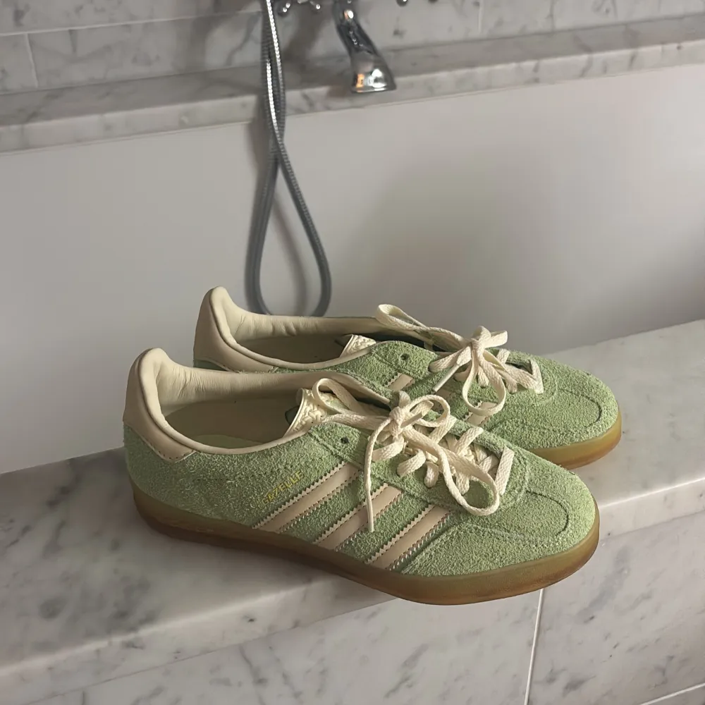 Snygga gröna sneakers från Adidas med krämfärgade detaljer och snörning. Skorna har en gummisula med bra grepp och är perfekta för en avslappnad stil. helt oanvända mamma köpte och använder aldrig dessa!! ingen förpackning för hon slängde . Kengät.
