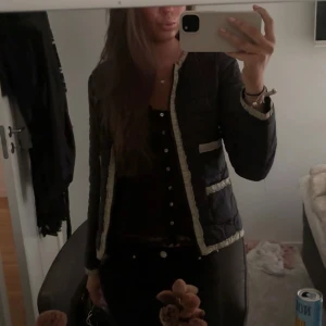 Marinblå quiltad jacka med vita detaljer - Snygg marinblå quiltad jacka med vita kanter och detaljer. Knappt använd, inga defekter😇