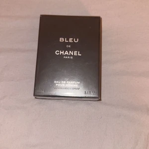 Bleu de Chanel Eau de Parfum - Säljer en elegant och tidlös Bleu de Chanel Eau de Parfum för herrar. Flaskan rymmer 100 ml och kommer i en stilren svart förpackning. Perfekt för den moderna mannen som vill ha en sofistikerad doft. Äkta oöppnad pris kan diskuteras vid snabb affär 