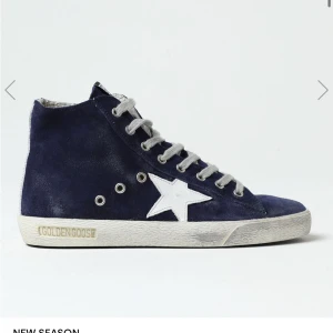 Blå sneakers från Golden Goose - Snygga blå sneakers från Golden Goose med vit stjärndetalj på sidan och vit sula. Skorna har snörning och en dragkedja på insidan för enkel på- och avtagning. Perfekta för en trendig och avslappnad stil.