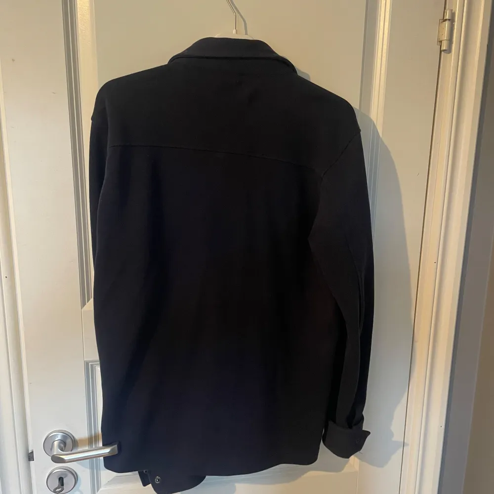 Säljer en stilren mörkblå overshirt från Selected Homme. Den har långa ärmar och knappar framtill samt två bröstfickor med knappar. Perfekt för vår, sommar och höst!. Takit.