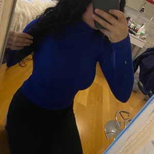 Blå ribbad polotröja -  en blå ribbad polotröja med långa ärmar. Ifrån Ginatricot, använt den några gånger men den är fortfarande i jättebra skick.