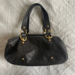 Väska - Snygg svart skinnväska med dubbla handtag och guldfärgade metalldetaljer. 💕💕Storlek: ca 30x15x10