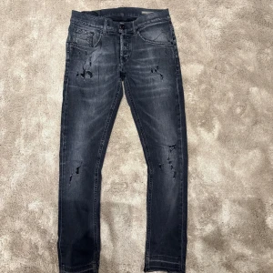Dondup jeans - Säljer nu dessa svart/grå dondup jeans med slitningar, då dem är för små för mig. De är använda men har inga defekter, förutom att färgen där bak försvunnit (bild 3) samt lite slitna längst ner. Slitningarna och hålen är från fabrik. Kvitto och tag finns.