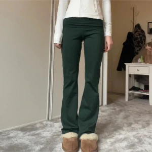 Gröna byxor med bootcut - Snygga gröna byxor med bootcut-stil och hög midja. Perfekta för en avslappnad look. De har en tight passform upptill och blir vidare nedtill, vilket ger en smickrande silhuett.