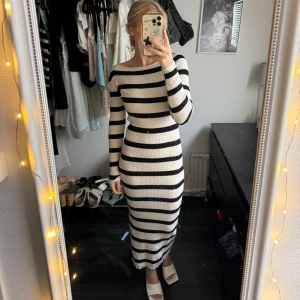 Randig klänning - Snygg långärmad klänning med svartvita ränder och en slits på sidan. Den har en tight passform. Använd endast 1 gång, precis som ny