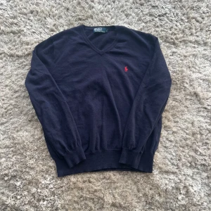 Ralph Lauren V neck - Tja! En stilren Ralph Lauren V neck med röd loga. Väldigt fint skick. Står L men passar även M. Pris kan diskuteras 🌟