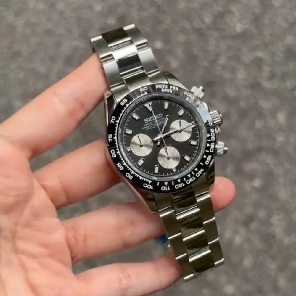 Seiko Mod Daytona är inspirerad av den ikoniska Daytona-designen och utrustad med den prestigefyllda Seiko VK63 hybridrörelsen. Denna 40 mm klocka kombinerar elegans och funktionalitet med hög tillgänglighet. Funktioner: • Diameter: 40 mm (utan krona) • Rörelse: Seiko VK63 hybrid (automatisk + kvarts) • Tjocklek: 12 mm • Glas: Safir, rep-resistent • Luminova: Ja • Material: 316L rostfritt stål • Bezel: Keramik • Armband: 316L stål med säkerhetslås • Vattentålig: 3 ATM • Fungerande kronograf: Ja. Asusteet.