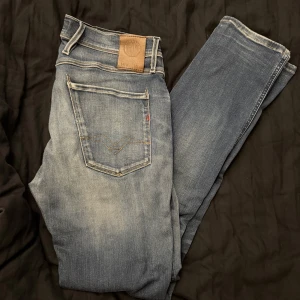 Replay jeans anbass - Feta Replay jeans i modellen anbass. Jeansen sitter slim fit och är ljus blå. Jeansen är använda och lite slitna men inget man märker vid användning!