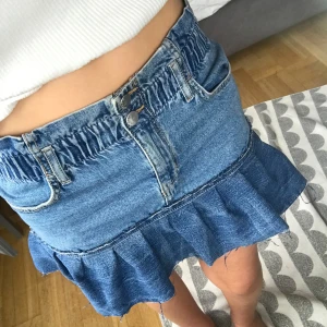 Jeanskjol med volang  - Supersöt blå jeanskjol med volang nertill och resår i midjan. Kjolen har både fram- och bakfickor. Jag har sytt den själv så den är inte felfri men allt syns på bilderna och inget påverkar funktionen! Resåren gör att den ser lite konstig ut nör den inte är på men nör man har på sig den är den jättefin! Lapparna ör borta så vet tyvärr inte märket. Jag har storlek 34 på jeans och Xs på kjolar och den passar mig bra🥰 Pris kan diskuteras och skriv om ni undrar något💓💓