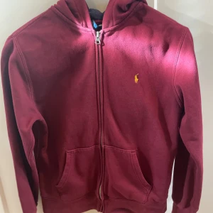 Vinröd hoodie från Polo Ralph Lauren - Hej, säljer min vinröda polo Ralph lauren ziphoodie. Den är i bra skick, men använd. Det är storlek L i barn (14-16 år).