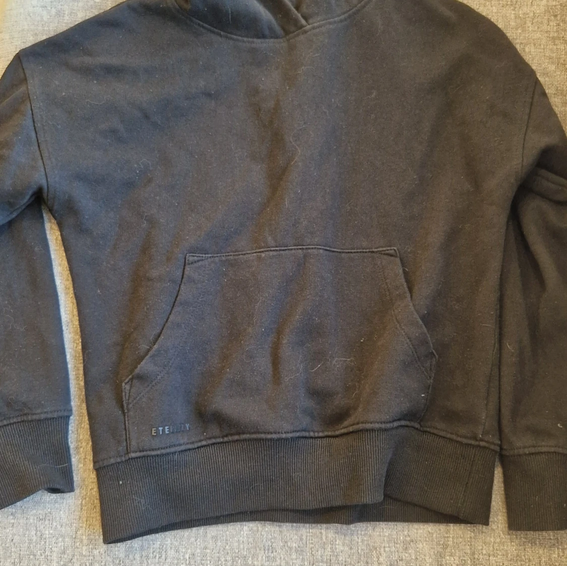 Svart hoodie från Wawai med ficka