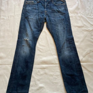 Replay Waitom jeans blå straight fit - Säljer ett par Replay Waitom jeans i klassisk blå/marinblå färg med slitningar. Jeansen har rak passform, fem fickor och snygga kontrastsömmar. Perfekta för dig som gillar en fräsch, snygg och avslappnad samt stilren look. Nypris: 1299, mitt pris: 401 kr + Fri frakt🤩.