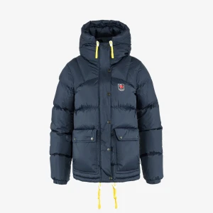 Mörkblå dunjacka från Fjällräven - Snygg mörkblå dunjacka från Fjällräven med huva och gula snören. Jackan har tryckknappar, dragkedja och två stora fickor framtill. Perfekt för kalla dagar och har en klassisk Fjällräven-logga på bröstet.