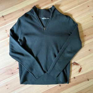 Mörkgrön half zip tröja från Dobber - Snygg mörkgrön tröja från Dobber med half zip-dragkedja och hög krage. Långärmad och i mjukt material som passar perfekt till lager-på-lager. Enkel och stilren design som funkar till många outfits.