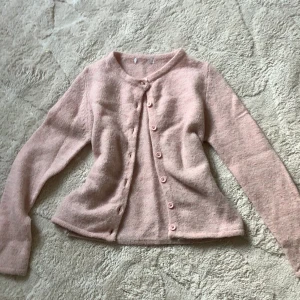 Rosa stickad kofta från Gina Tricot - Rosa stickad kofta, en lapp är bortklipp och är nopprig men går att fixa! Tröjan är använd många gånger, men säljer för den inte kommer till användning. 