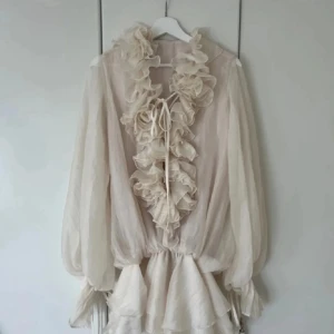 Klänning  - Superfin kort klänning med volanger längs halsringningen och framtill. Långa, luftiga ärmar och omlottkänsla vid kjolen. Den är precis lagom lång och perfekt för dig som gillar unika detaljer. Har tyvärr inte kommit till användning. Ny pris 1000 kronor. 💕