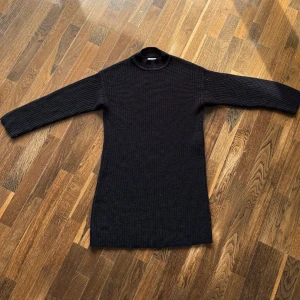 Stickad klänning från JDY - Mysig, fin svart stickad klänning från JDY i storlek XS. Klänningen har lång ärm, rundad hals och grovstickad struktur som ger en varm, stilren och enkel look. Jättefin att styla med boots, pumps eller sneakers! (Använd endast en gång). 