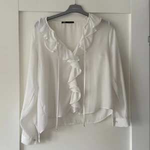 Vit blus  - Så fin vit blus med lite volangdetaljer ✨ Perfekt både till vardags och när du vill va lite mer uppklädd. Den är använd ett få antal gånger och ser som ny ut!  