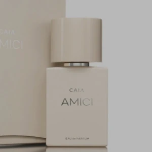 CAIA Amici Eau de Parfum - Snygg och stilren parfymflaska från CAIA med namnet Amici. Flaskan är rektangulär och har en matt beige färg med ett matchande lock. Modern design som känns lyxig och minimalistisk, perfekt att ha framme på hyllan.
