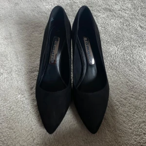 Klackar från Tamaris i mocka - Klassiska svarta pumps från Tamaris i storlek 38. Skorna har spetsig tå och hög klack, tillverkade i mjuk mocka som ger en elegant look. Perfekta för vardaglig användning💗Bara använda hemma!