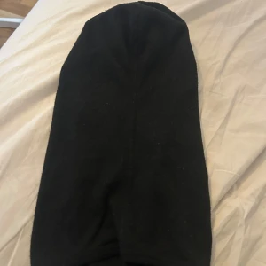 Svart skidmask och adidas mössa - Säljer en svart skidmask från Mountain Works med diskret logga, perfekt för kalla dagar. Materialet är mjukt och täcker hela huvudet. Medföljer även en svart ribbstickad mössa med uppvikt kant, enkel och stilren design. Adidas mössan är använd 2 gånger annars i rent och fint skick. Priset gäller för båda 