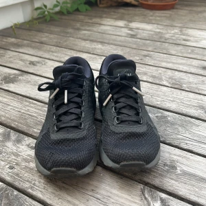 Svarta Nike Air Max sneakers - Snygga svarta Nike Air Max sneakers med mesh och syntetmaterial. Skorna har klassisk snörning och en dämpad sula för extra komfort. Perfekta för dig som gillar en sportig och stilren look.