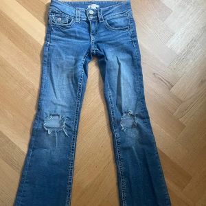 Blå jeans med slitna knän från Gina Tricot - Snygga blå bootcut jeans från Gina Tricot med slitna hål på båda knäna ( hålen är hemmagjorda) väldigt fina.