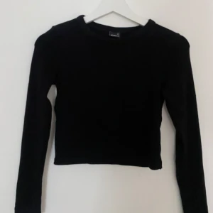 Svart långärmad tröja Gina Tricot XS - En stilren svart långärmad tröja från Gina Tricot i storlek XS. Modellen är enkel med rund hals och normal passform. Materialet är tjockare och skönt.