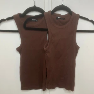 Bruna ribbade linnetoppar BikBok XS - Två bruna ribbade linnetoppar från BikBok i storlek XS. Modellen är ärmlös med rund halsringning och sitter tight mot kroppen. Jag säljer båda för 45-50kr.