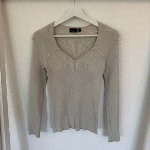 Beige/grå ribbad ,stickad , glittrig tröja från KappAhl  - Supersnygg beige/grå stickad tröja från KappAhl med ribbad struktur och v-ringad hals. Långärmad och figurnära passform som sitter riktigt bra. Materialet har en lätt glittrig effekt. V-ringingen ger en jättefin passform vid bröstet. Endast använd en gång. Pris går att diskutera!