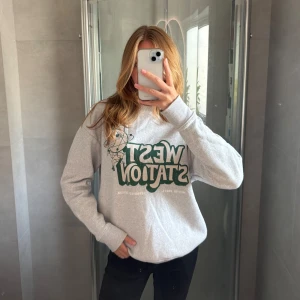 Ljusgrå collegetröja med tryck - Ljusgrå sweatshirt/collegetröja med mörkgrönt tryck. Storlek 38 från Pull and Bear. Superskön och otrolig passform.