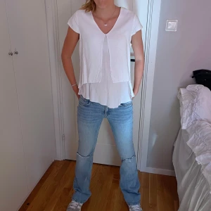 Snygg vit T-shirt med detalj! - En vit T-shirt med snygg volang detalj framtill. Den är använd några gånger! 💗