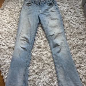 Ljusblå bootcut jeans från Zara - Säljer ett par ljusblå jeans från Zara i klassisk bootcut-modell. Jeansen har fem fickor, dragkedja och knapp framtill samt snygga slitningar för en avslappnad vibe. Perfekta för dig som gillar en retroinspirerad look. Dragkedja åker lätt ned, nästan aldrig använt. 
