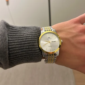 Klocka - En fin klocka som är helt ny och aldrig använd. Klockan är färgat i guld och silver (varken äkta guld eller silver). Hör av dig vid frågor eller funderingar