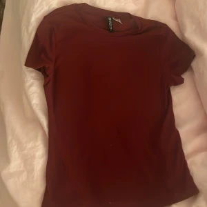 Vinröd t-shirt från H&M Divided XXS - En enkel och stilren vinröd t-shirt från H&M Divided i storlek XXS. Jag tycker personligen att den är för genomskinlig. Så förvänta er inte en super täckande tshirt. Jag tar såklart en jätte bild där jag har den på om nån är intresserad. Och den kommer självklart tvättas innan, så tänk inte på nån vit fläck eller så!