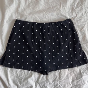 Minikjol med inner-shorts - (Shortsen syns inte när kjolen sitter på!) Svart och vitprickig minikjol, som har inbyggda inner-shorts, små slits på vardera sida. Storlek S, från Cider. Helt nya, aldrig använda. Jag fraktar gärna - köparen står för frakten, annars hämtas kjolen upp i Tyresö/Globen 💞(bilden visar framsida, baksida och insida i ordning) 