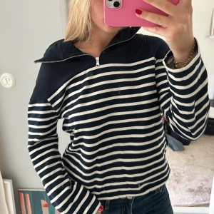 Randig hoodie med half zip och huva - Säljer en snygg randig hoodie i marinblått och vitt med dragkedja upptill och stor huva. Tröjan har långa ärmar och är tillverkad i mjuk bomull.