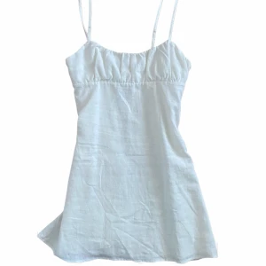 Vit kort klänning från Bershka! - Supersöt vit kort klänning från Bershka med lätt rynkad byst. Gjort i linne💗står som strl S men har en liten passform, skulle nog kunna passa XS. Aldrig använd!
