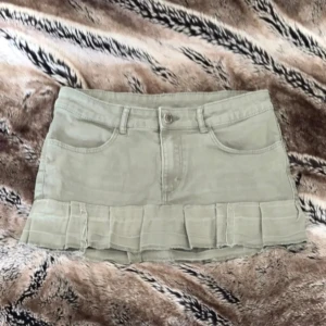 Grön minikjol med volangkant - Supersöt grön minikjol i jeansmaterial med volangdetalj längst ner. Kjolen har klassiska fickor fram och bak. Den är syd själv💗💗