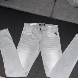 Ljusgrå Replay anbass Hyperflex jeans - Är lite små i storlek!!! Säljer ett par ljusgrå Replay Hyperflex jeans med klassisk femficksdesign och svarta detaljer. Jeansen har raka ben och är tillverkade i stretchigt material för extra komfort. Perfekta för dig som vill ha en stilren och modern look. Pris kan diskuteras 