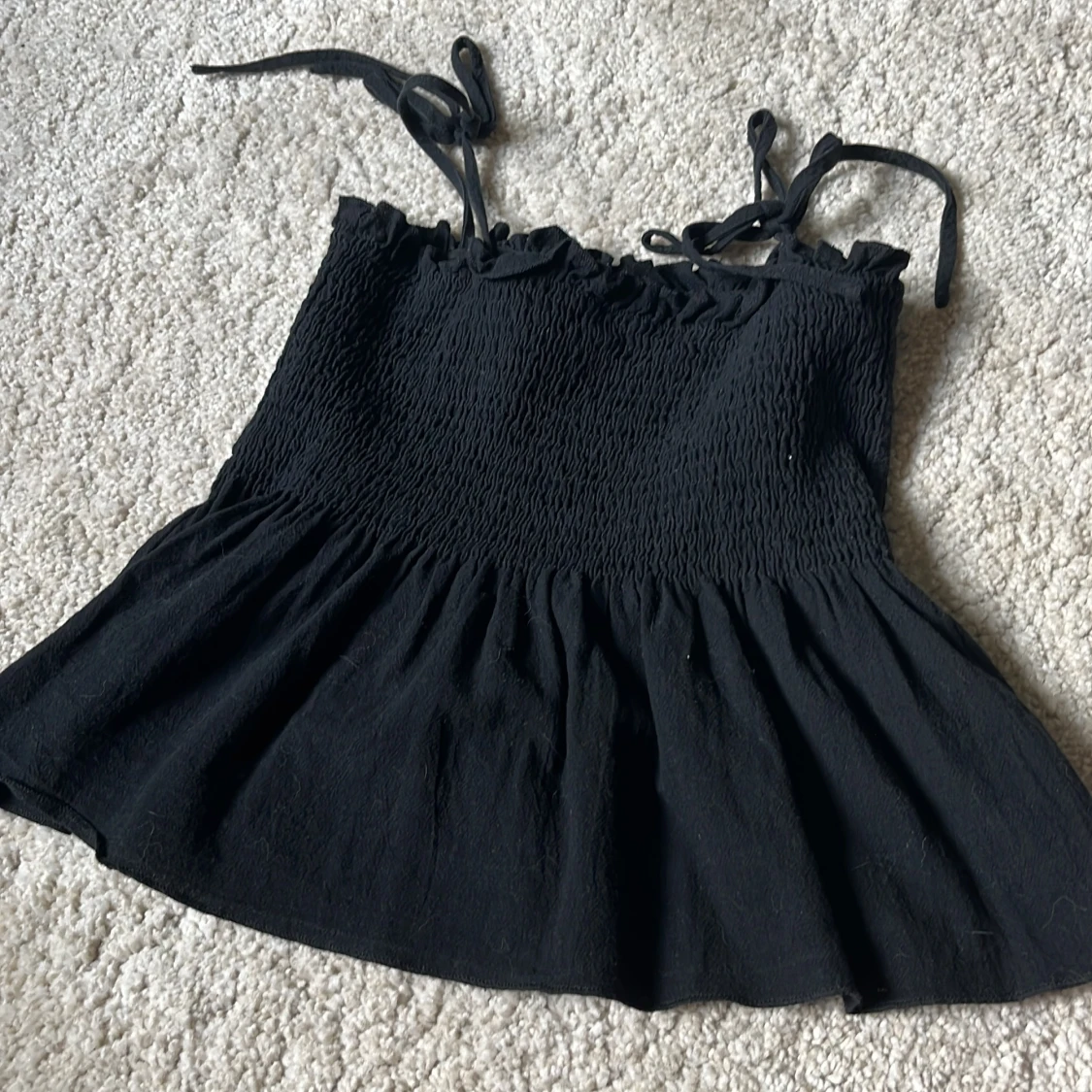 Svart smockad linnetopp från Loness