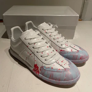 Maison margiela GATS - Säljer nu dessa riktigt snygga och unika gats från Maison margiela. Utmärkt skick, 10/10. Box tillkommer. Storlek 44 och de sitter som en vanlig 44a. Färgen är vit med ljusblå och röd färgsplatter. Hör av er vid funderingar. OBS: 1NTE ORG1NAL!!