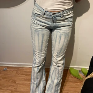 Ljusblå bootcut jeans från Enimone - Säljer ett par ljusblå bootcut jeans från Enimone med coolt tvättat mönster. Jeansen har hög midja, klassiska fem fickor och är tillverkade i mjukt denimtyg. Snygg passform med utsvängda ben och unikt blekt mönster. 😊inga fläckar eller hål