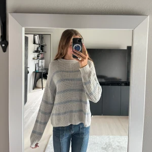 Stickad tröja - Stickad blå-vit randig tröja. Lite av sömmen längst ner där bak har gått upp, men inget man tänker på. Finns även någon enstaka fläck. Hör av dig om du har några frågor eller funderingar!🩷