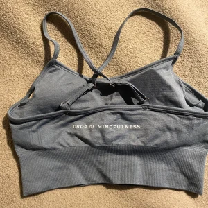 Sportbehå - Superskön sportbehå från Drop of Mindfulness (DOM) Tillkommer pads (se bild 3). Knappt använd, då den bara legat i garderoben pga att jag har långa likadana i andra färger (denna ser ut som blå, men är mer åt d gröna hållet)                                       Perfekt för träning, gym och liknande🫶🏼Storlek S. Vid mer info osv, hör gärna av dig💗