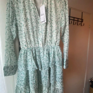 Söt sommarklänning - Supersöt klänning från Gina Trickt i mintgrönt och blommigt mönster. Klänningen är helt ny med prislapp kvar. Perfekt för vår och sommar💗