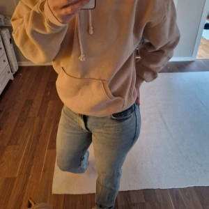 Beige hoodie från BikBok med huva - Säljer en beige hoodie från BikBok i storlek S. Tröjan har en klassisk känguruficka, ribbade muddar och snörning i huvan. Perfekt för chill dagar och enkel att matcha med jeans eller mjukisbyxor.